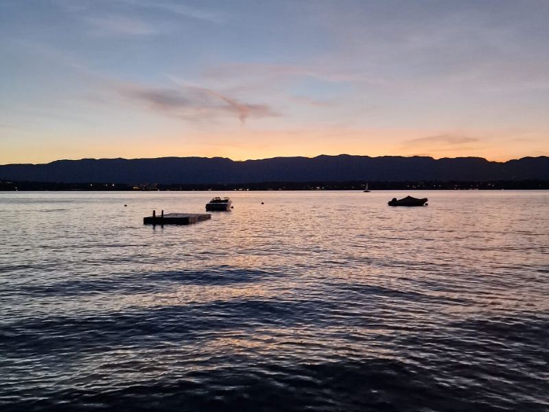 Abendrot über dem Genfer See, Boote liegen ruhig vor Anker